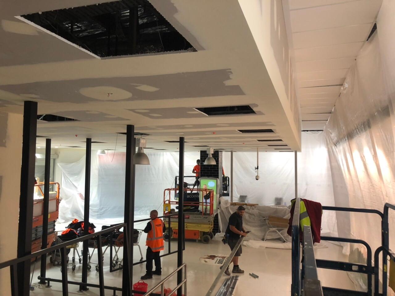 Mezzanine ceiling being lined with plasterboard inside a retail fit-out