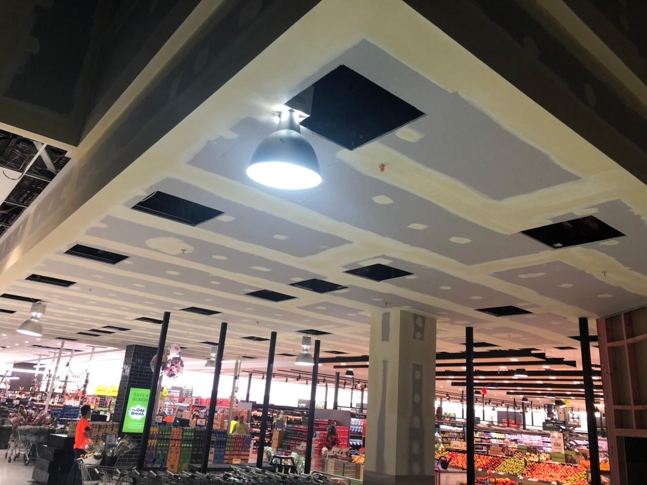 Stopped plasterboard ceiling bulkhead above a supermarket entrance