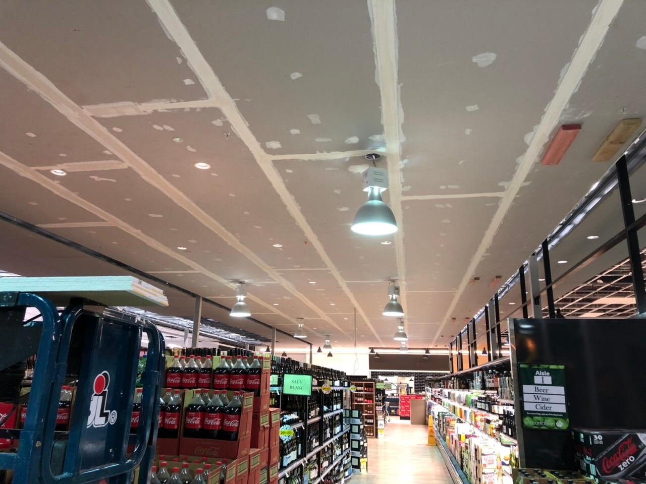 Long supermarket aisle ceiling with stopped plasterboard joins