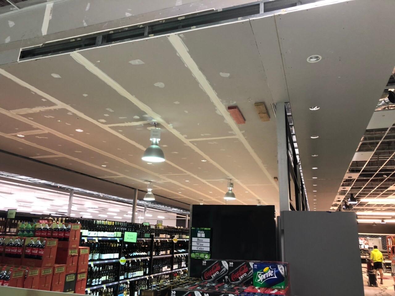 Plasterboard ceiling and bulkhead finished over supermarket shelving